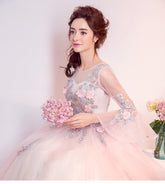 Woman in a pink and silver dress holding flowers against a light background