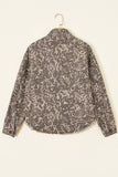 Long-sleeve collared shirt jacket with distressed dark gray and beige abstract pattern on wooden hanger.