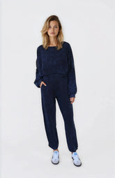 Woman wearing a navy blue outfit with white sneakers on a white background