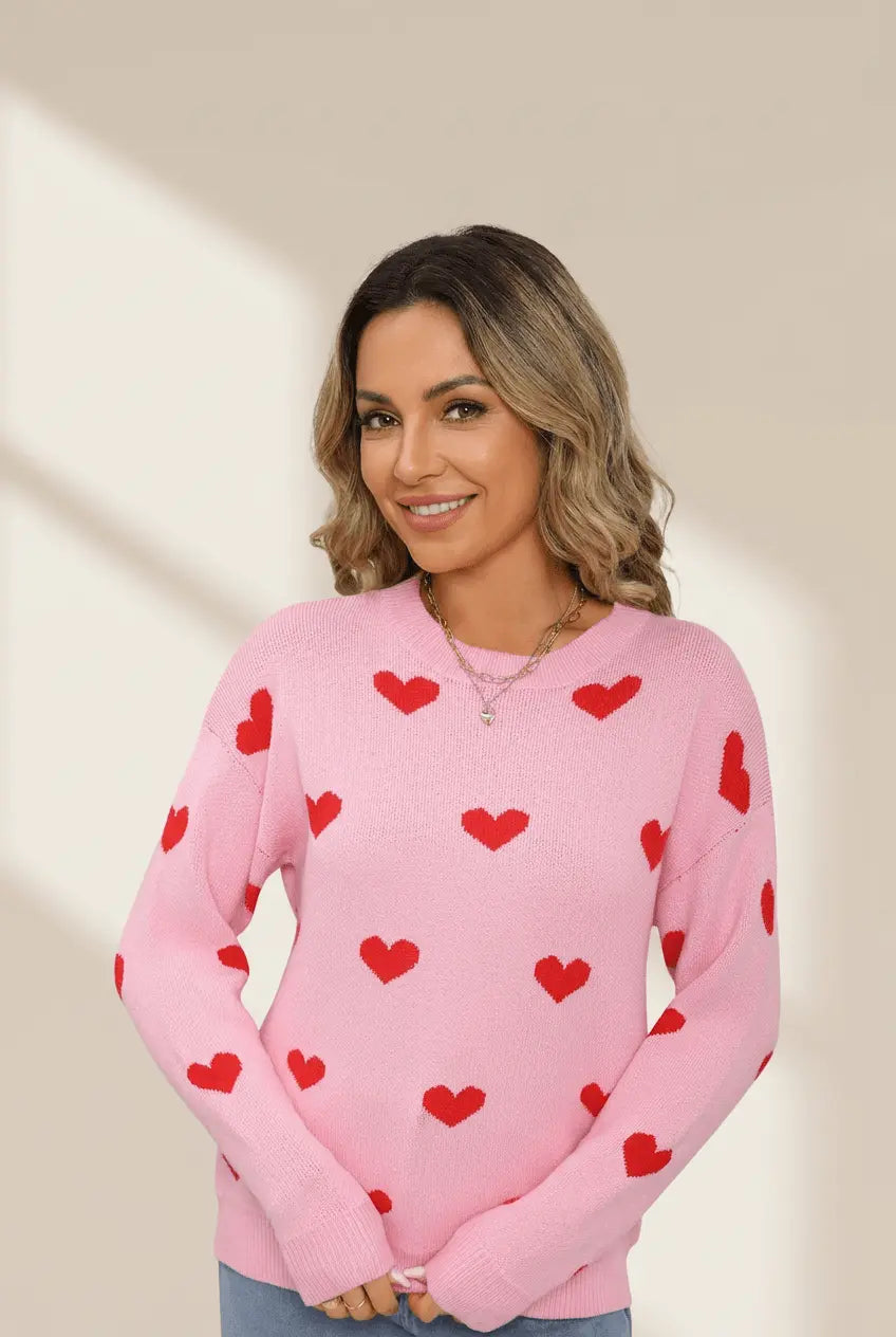 Woman wearing a pink sweater with red heart patterns on a beige background