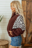 Woman in brown sherpa fleece jacket with leopard-print sleeves and denim shorts.