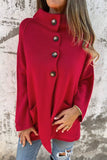 Red coat with button details worn by a person against a textured wall background