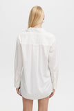 Person wearing a white shirt on a plain background