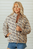 A woman wearing a beige and brown camouflage print jacket with a high collar.