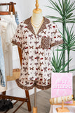 Mannequin wearing a patterned blouse with bows and cherries in a store setting.