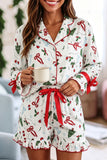 Woman in white Christmas-print pajama set with ruffled shorts and mug.