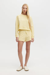 Woman wearing a yellow outfit on a white background
