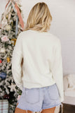 A woman viewed from behind wearing an off-white crewneck sweatshirt and light-wash denim shorts.