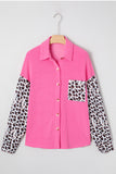 Pink shirt with leopard print sleeves and pocket on a hanger against a white background.