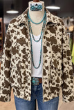 Cow-print jacket on mannequin styled with white top, blue jeans, turquoise necklaces, and belt buckle.