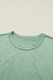 Close-up of a green t-shirt with a plain background