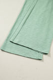 Folded green fabric on a beige surface
