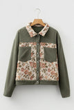Green jacket with floral patterns on a wooden hanger against a white background