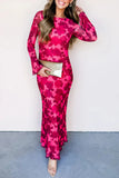 Woman wearing a pink floral dress holding a clutch against a white background
