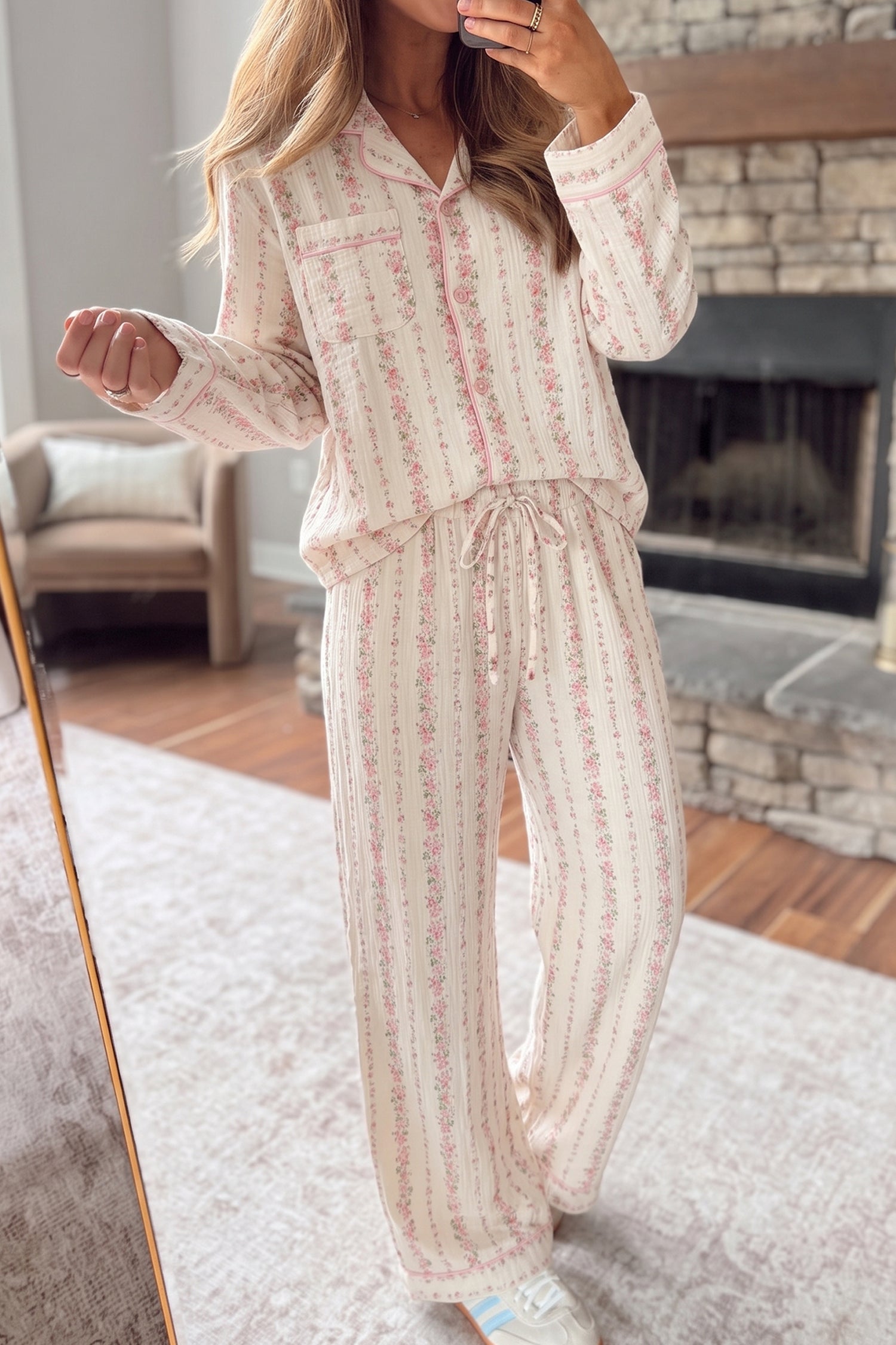 Woman in cream pajama set with pink floral vertical stripes.