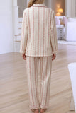 Back view of woman in cream pajamas with pink floral stripes.