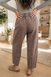 Person wearing brown pants and a gray top in a home setting