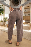 Person wearing brown pants and a gray top in a home setting