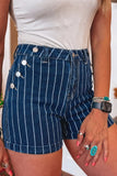 A close-up of a person wearing dark blue denim shorts with thin white vertical pinstripes and decorative silver-tone buttons on the side, paired with a white top.