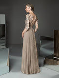 Woman wearing a long, elegant dress with intricate detailing in a modern setting.