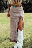 Person wearing a leopard print skirt with a slit, brown top, and white cowboy boots in a grassy outdoor setting.
