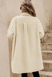Person wearing a cream-colored sherpa coat standing on wooden steps.