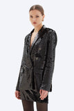 Woman wearing a black sequin blazer on a white background