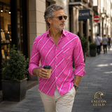Man in a pink checkered shirt walking on a city street holding a coffee cup.