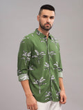 Man wearing a green patterned shirt against a gray background
