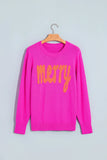 Bright pink knit sweater with “Merry” in orange-yellow cursive on chest.