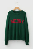 Green sweatshirt with 'MERRY' in red on a hanger against a white background