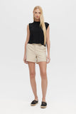 Woman wearing a black sleeveless top and beige shorts on a white background