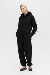 Person wearing a black outfit with lace details on a white background