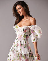 Woman wearing a floral off-shoulder dress against a gray background