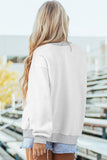 Person wearing a light gray sweatshirt with a blurred indoor background