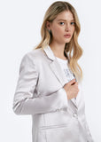 Woman wearing a light gray blazer over a white shirt on a white background