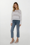 Woman wearing a light gray striped sweater and blue jeans on a white background