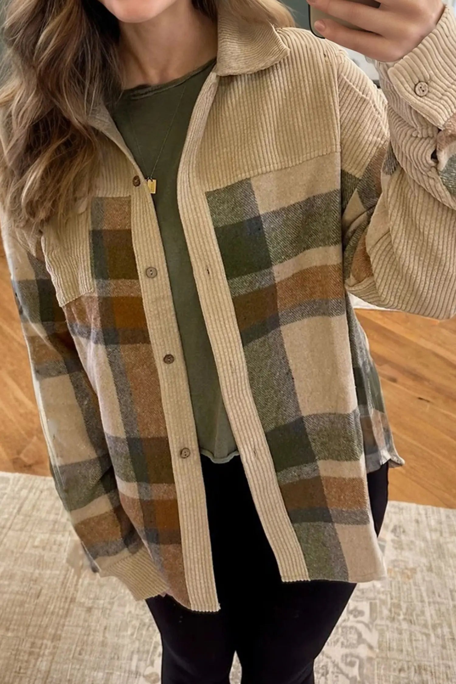 Person wearing a plaid shirt with a neutral color palette indoors.