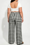 Person wearing a white top and black and white checkered pants on a white background