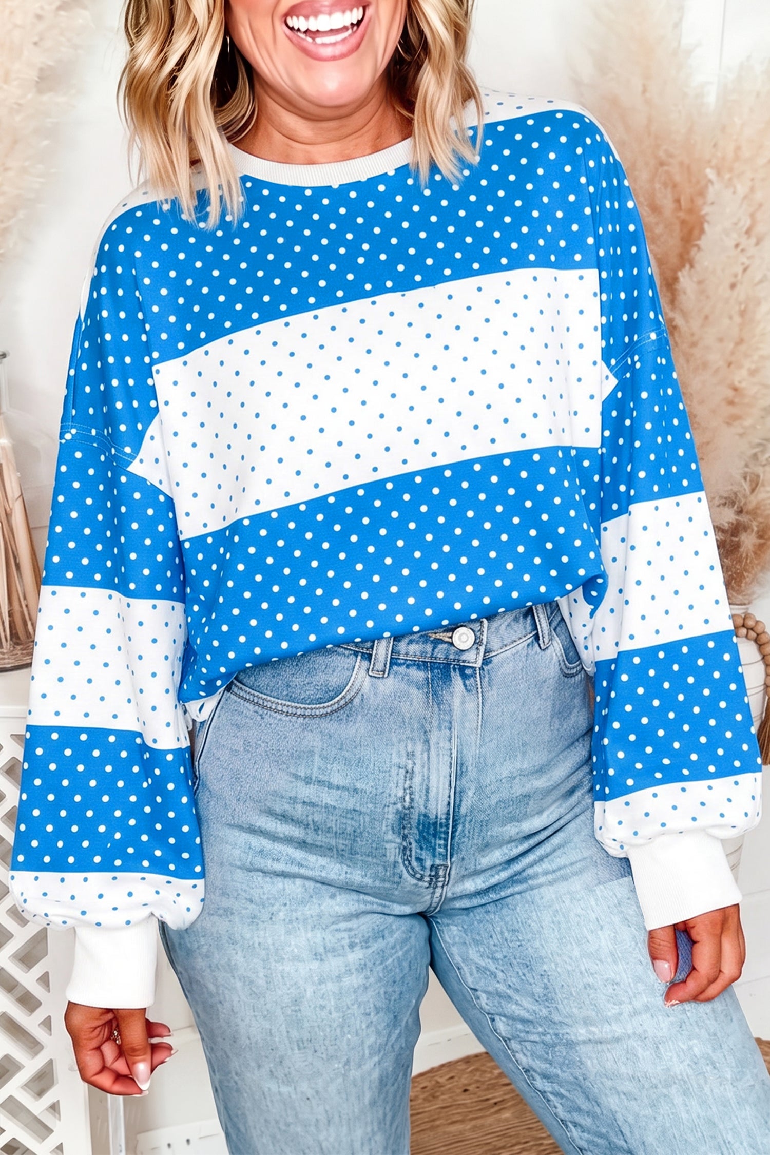 Woman wearing a blue and white striped top with white polka dots and light-wash jeans.