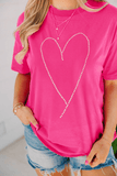 Person wearing a pink t-shirt with a heart design, standing against a white background