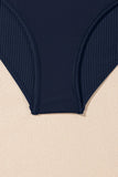 Navy blue ribbed swimsuit bottom on a beige background
