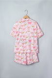 Light pink pajama set with Santa faces and pink bows on hanger.