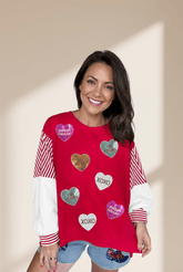 Woman wearing a red sweater with heart-shaped decorations on a beige background