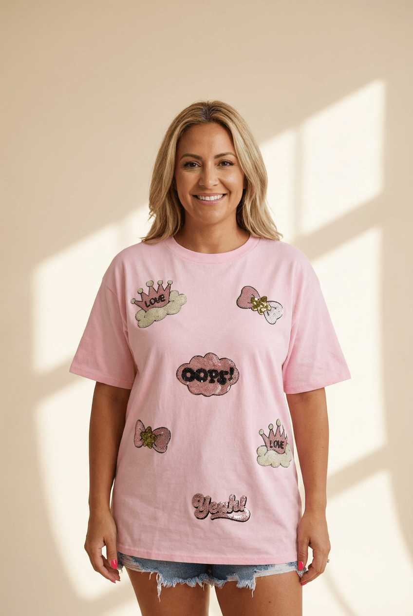 Woman wearing a pink t-shirt with various designs on a beige background