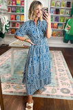 Woman taking a selfie in a patterned dress in a store.