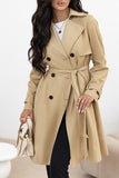 Woman wearing a beige trench coat with a white background