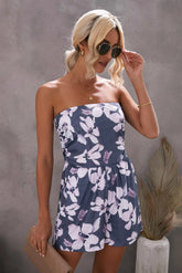 Woman wearing a strapless floral dress against a gray background