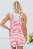 Person wearing a pink and white striped romper with a white background