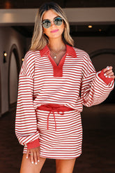 Woman wearing a red and white striped dress with sunglasses indoors.